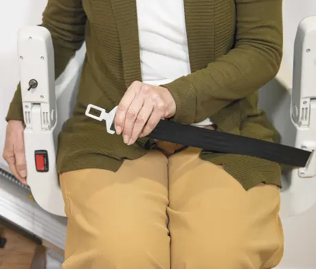 Woman is putting seatbelt on in the S100 stairlift